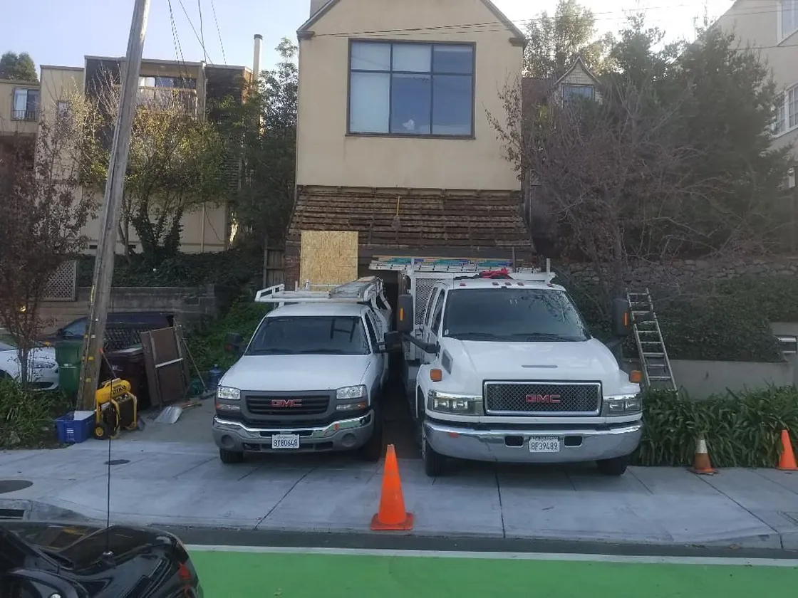 Two Franco Roofing trucks parked at a Bay Area residential job site