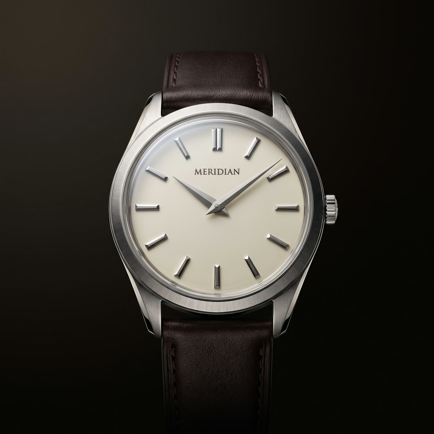 The Founder's Hour: a 40 millimeter brushed steel watch with an ivory dial and dark brown leather strap, photographed face on under champagne light