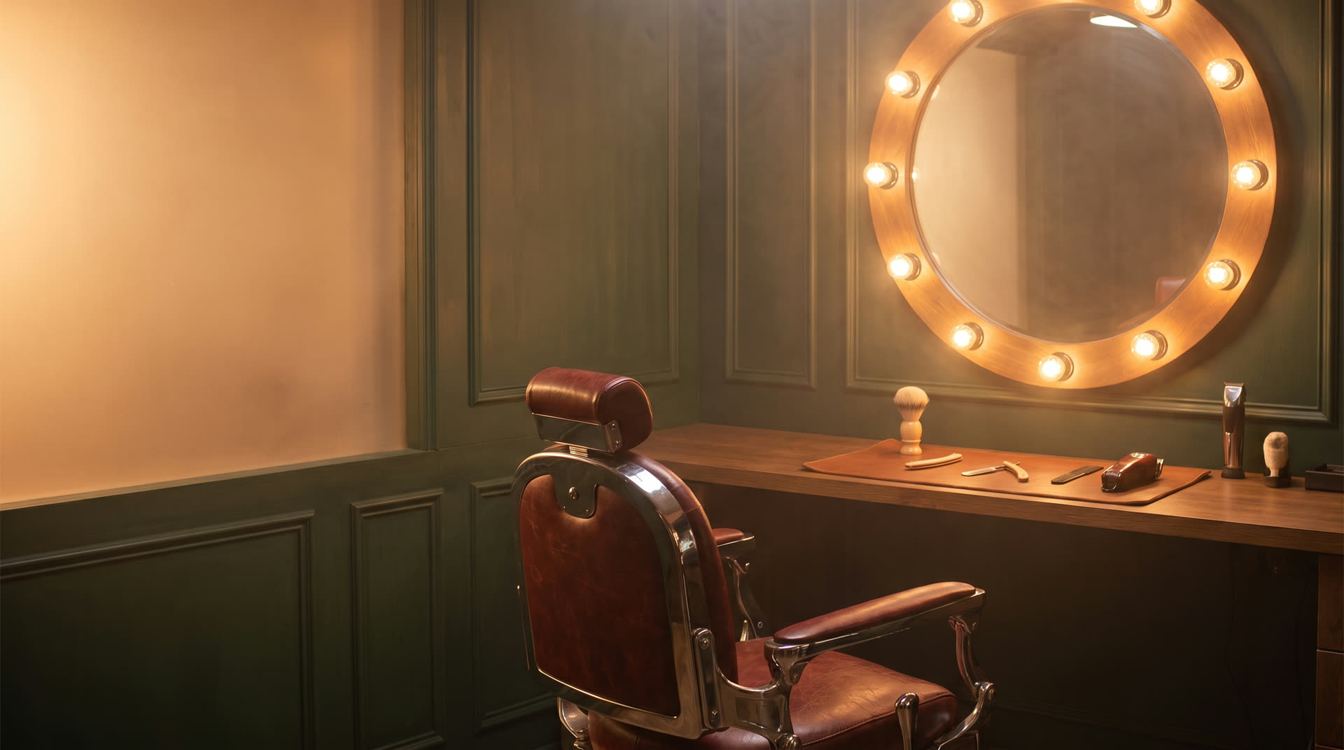 Interior of Union Barber Co., a green-paneled shop with an oxblood leather barber chair and a brass-lit round mirror